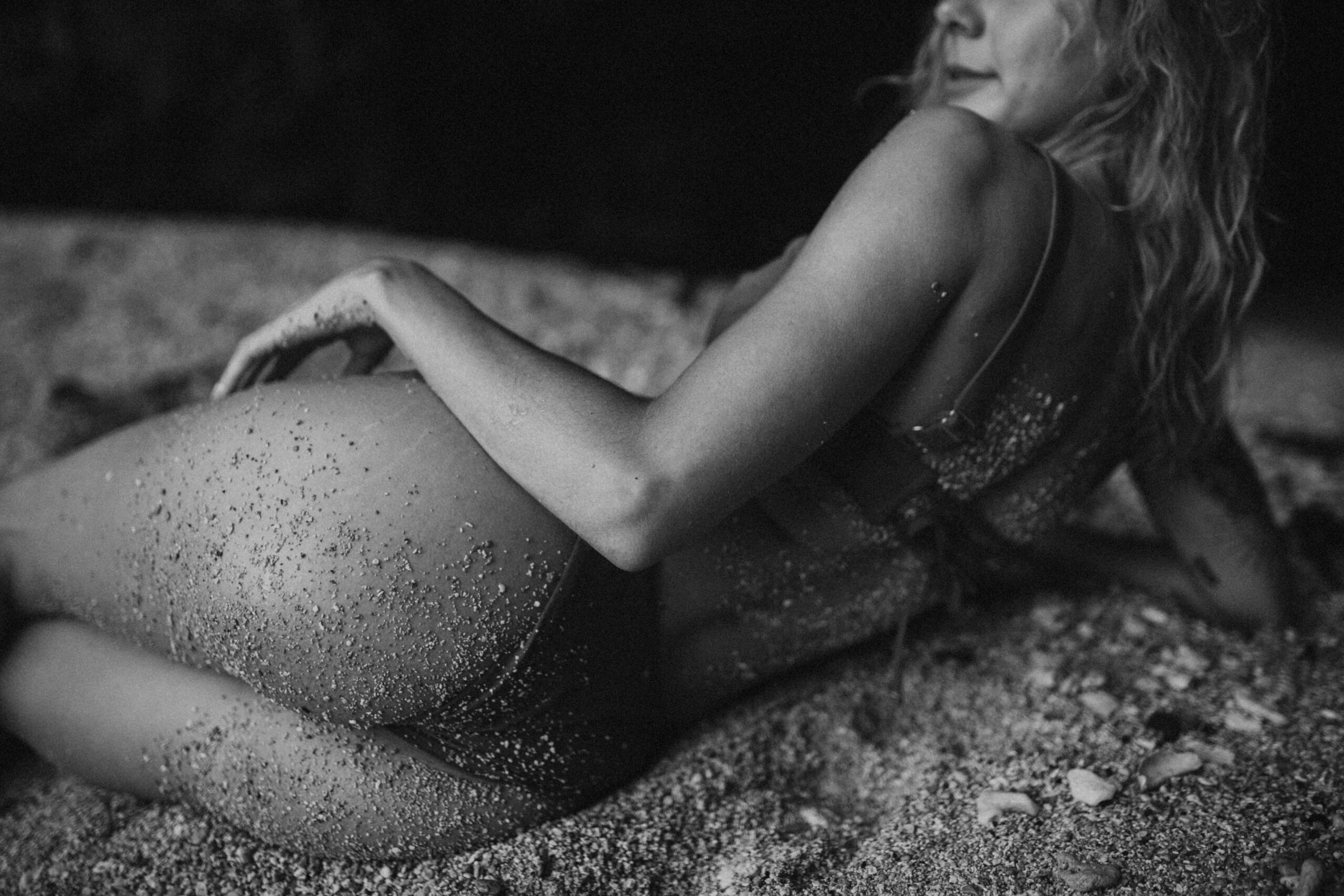 woman poses in the sand for her boudoir photo shoot in kauai, hawaii